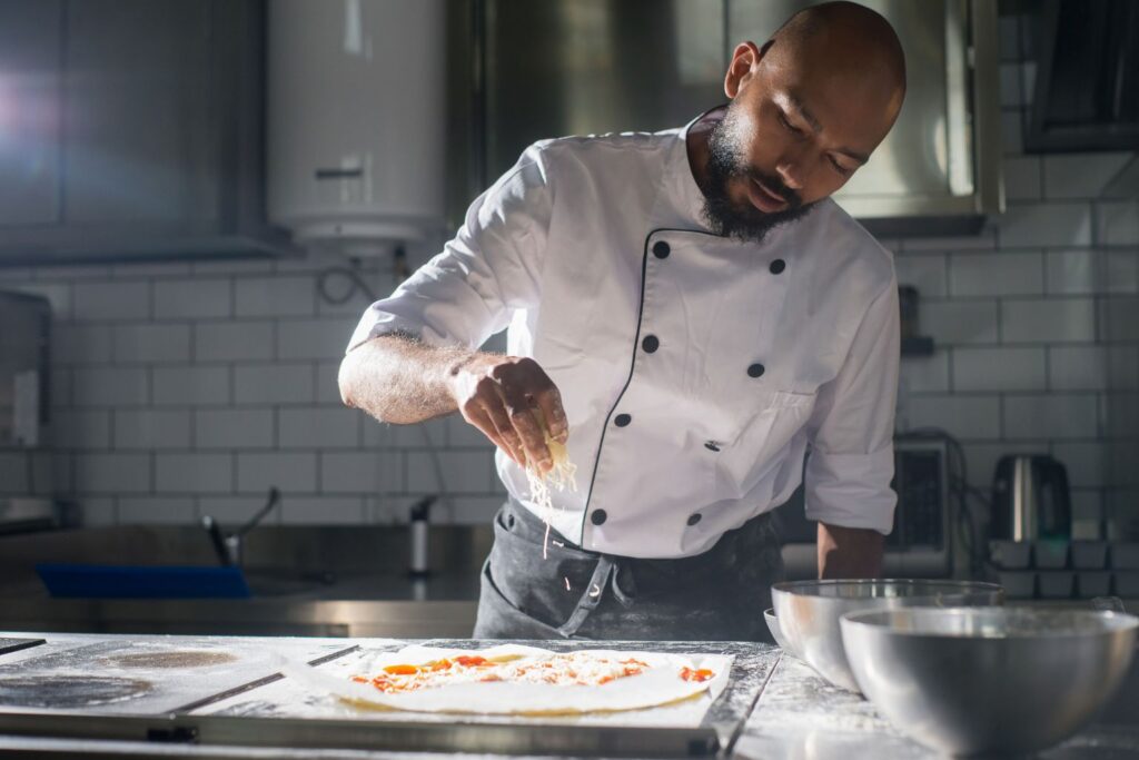 Chef preparing a pizza in a commercial kitchen